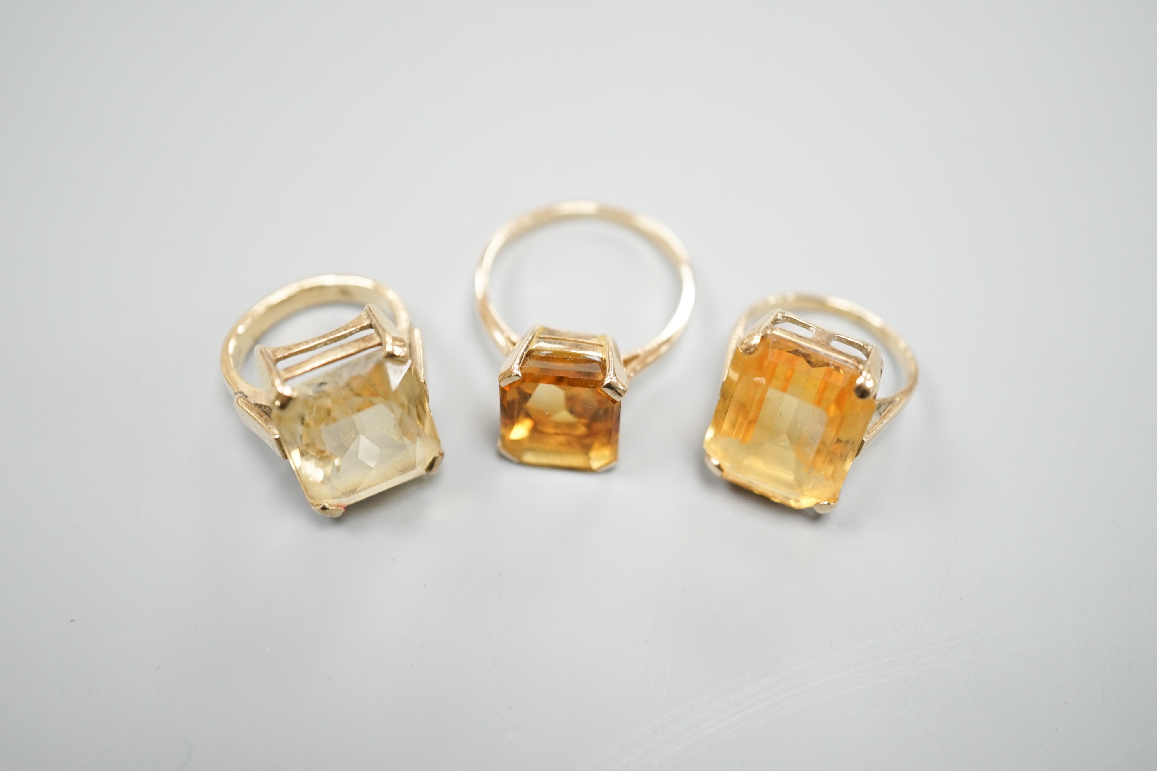 Three yellow metal and citrine set dress rings, one stamped 9ct, gross weight 11.9 grams.